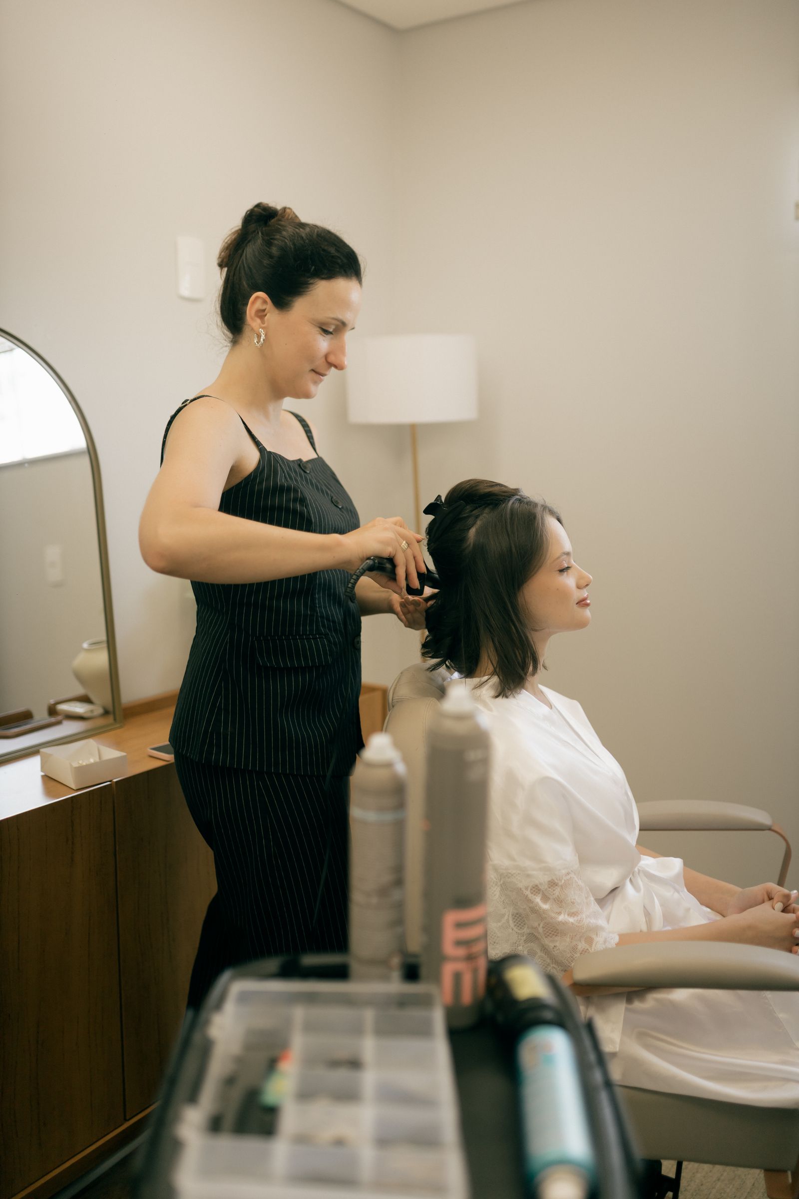 A stylist carefully arranging a client's hair